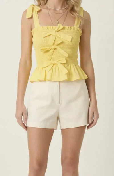 Modenaire Smocked Peplum Top With Bow Tie Straps And Ruffle Hem In Yellow