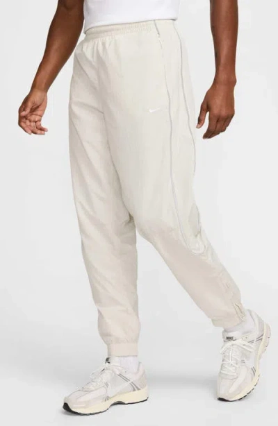 NIKE NIKE SOLO SWOOSH WATER REPELLENT TRACK PANTS