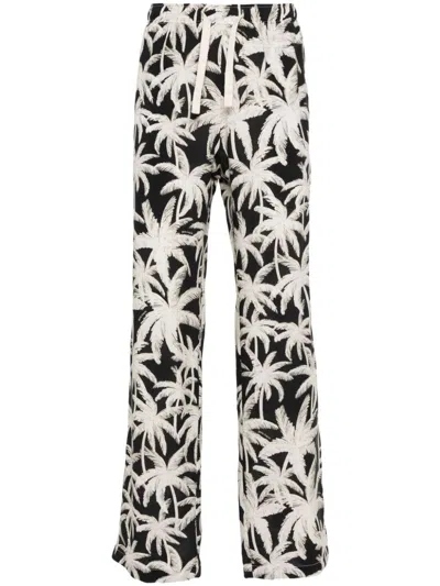 PALM ANGELS LOOSE FIT ALL-OVER LOGO TROUSERS IN BLACK FOR MEN