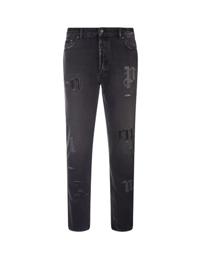 PALM ANGELS SLIM FIT JEANS IN BLACK DENIM WITH APPLICATION