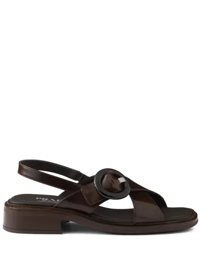 Prada Brushed Leather Crisscross Band Sandals With Plexiglas Buckle In Bruciato