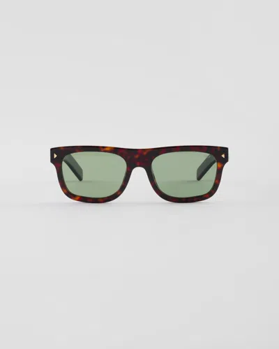 PRADA SUNGLASSES WITH THE ICONIC METAL PLAQUE