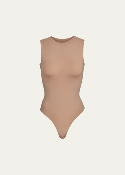 Skims Essential Sleeveless Crewneck Thong Bodysuit In Sienna