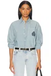 Sporty And Rich Health & Wellness Crest Oversized Button Down Top In Chambray