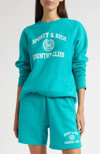 Sporty And Rich Sporty & Rich Varsity Crest Crewneck Graphic Sweatshirt In Blue