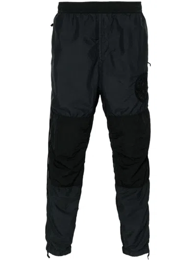 Stone Island Logo-patch Creased Tapered Trousers In Black