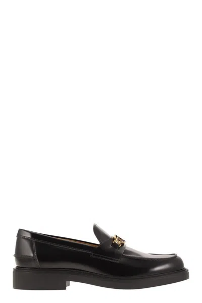 Tod's Shiny Leather Moccasin With Gold Metallic Logo In Black