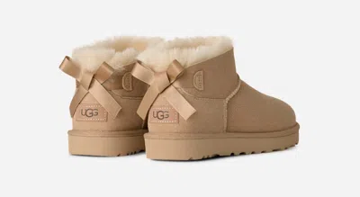 Ugg ® Women's Ultra Mini Bailey Bow Sheepskin Classic Boots In Sand In Brown