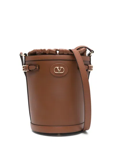 Valentino Garavani Valentino Logo-plaque Leather Drawstring Bucket Bag In Brown