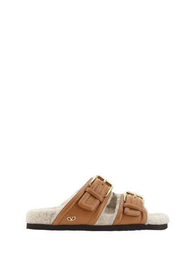 Valentino Garavani Buckled Shearling Slides In Brown