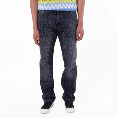 Versace All-over Logo Denim Jeans In Blue
