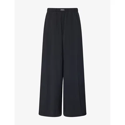 We Are Tala Omens  Wide-leg Silicone-branding Studio Trousers In Black