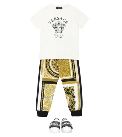 Shop Versace Printed Cotton-jersey Trackpants In Gold