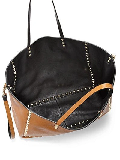 Shop Valentino Reversible Studded Leather Tote In Black-cognac
