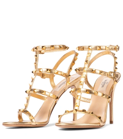 Shop Valentino Rockstud Leather Sandals In Gold