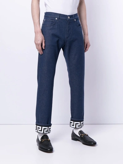 Shop Versace Turned-up Hem Slim-fit Jeans In Blue