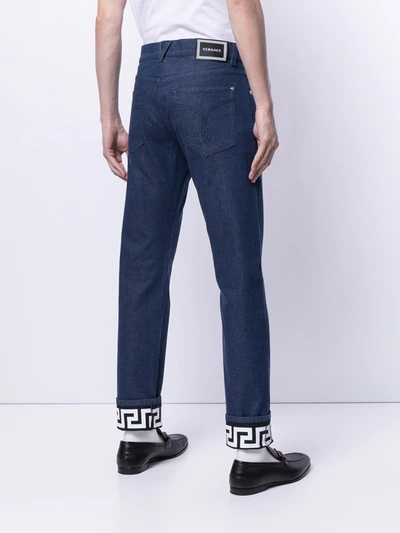 Shop Versace Turned-up Hem Slim-fit Jeans In Blue