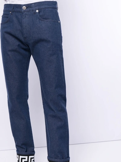 Shop Versace Turned-up Hem Slim-fit Jeans In Blue