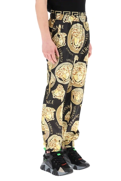 Shop Versace Amplified Medusa Print Trousers In Black,gold