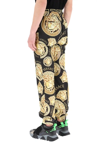 Shop Versace Amplified Medusa Print Trousers In Black,gold