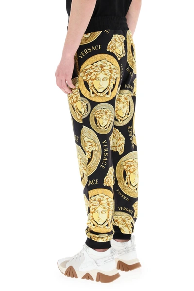 Shop Versace Amplified Medusa Print Jogging Trousers In Black,gold