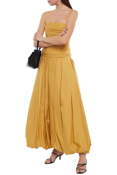 Shop Khaite Ingrid Strapless Pleated Cotton-poplin Maxi Dress In Mustard