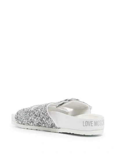 Shop Love Moschino Glitter Buckled Slides In Grey