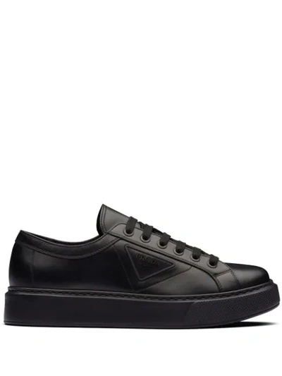 Shop Prada Logo Embossed Low-top Sneakers In Black