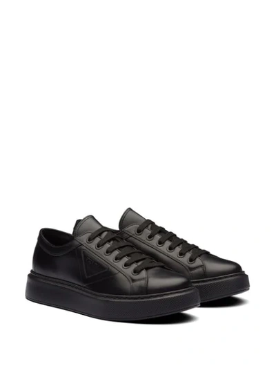 Shop Prada Logo Embossed Low-top Sneakers In Black