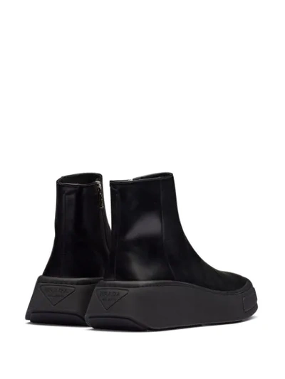 Shop Prada Zipped Wedge Sole Boots In Black