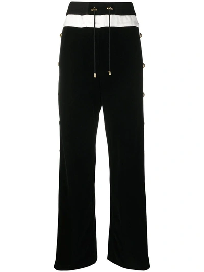 Shop Balmain Flared Black And White Trousers With Buttoned Legs