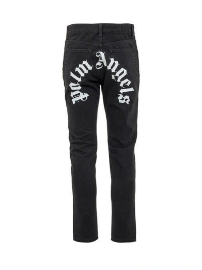 Shop Palm Angels Curved Logo Print Jeans In Black