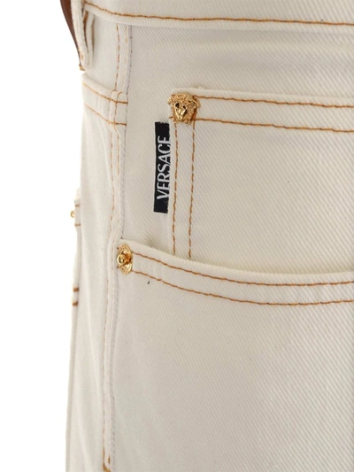 Shop Versace Mid Rise Straight Leg Jeans In White