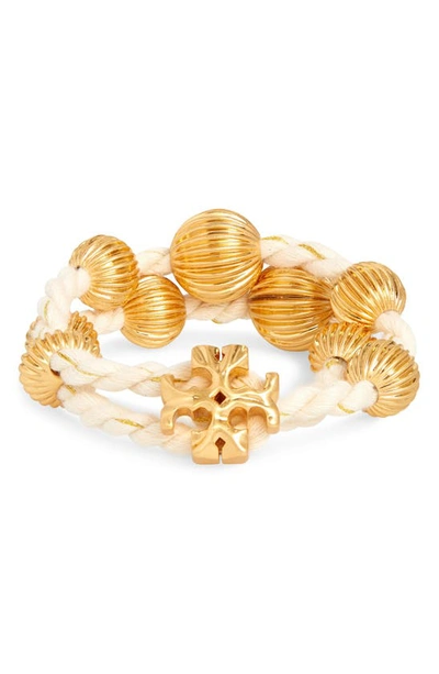 Shop Tory Burch Roxanne Logo Wrap Bracelet In Rolled Brass / Ivory