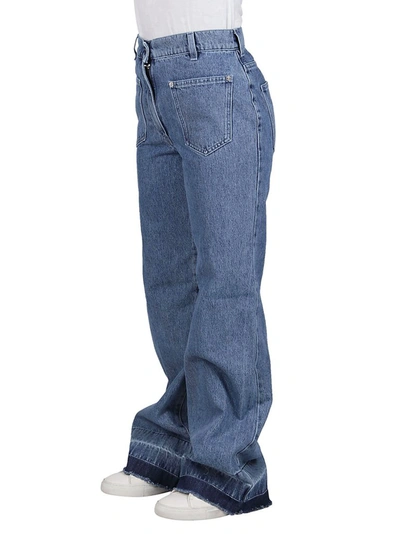 Shop Jw Anderson Bootleg Raw Hem Jeans In Blue