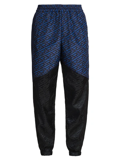 Shop Versace Men's Tech Monogram Print Track Pants In Black Blue