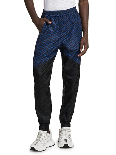 Shop Versace Men's Tech Monogram Print Track Pants In Black Blue