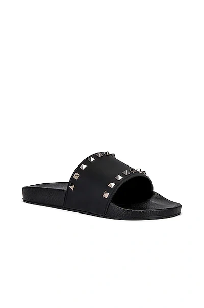 Shop Valentino Rockstud Slide Sandals In Black