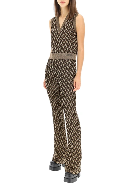 Shop Versace La Greca Jacquard Lurex Knit Trousers In Black,gold,brown