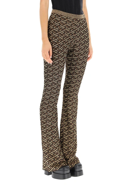 Shop Versace La Greca Jacquard Lurex Knit Trousers In Black,gold,brown