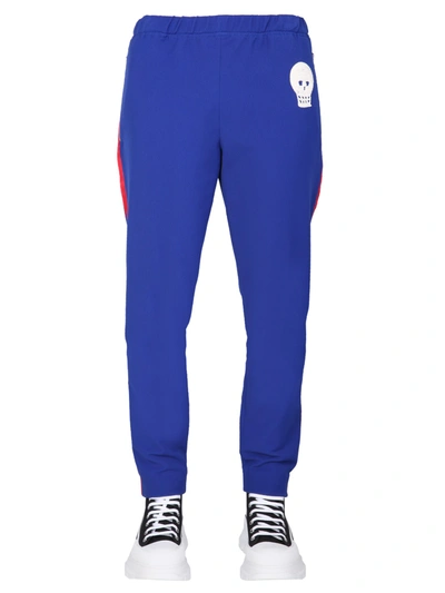 Shop Alexander Mcqueen Jogging Pants With Embroidered Skull In Blu