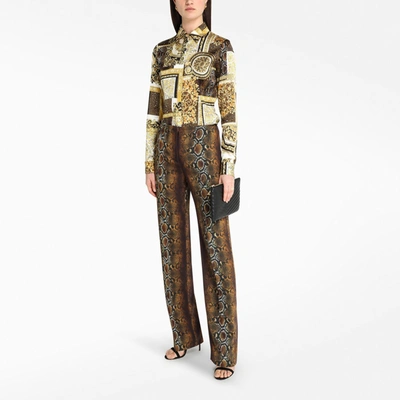 Shop Versace Phyton Print Trousers In Brown