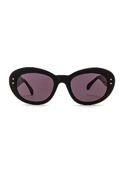 Shop Alaïa Oval Sunglasses In Shiny Black