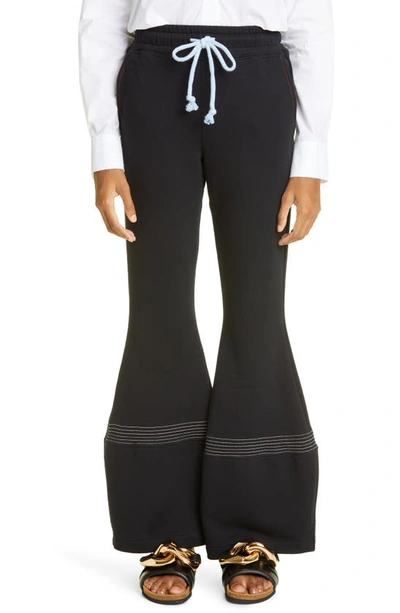 Shop Jw Anderson Flared Cotton Track Pants In Black