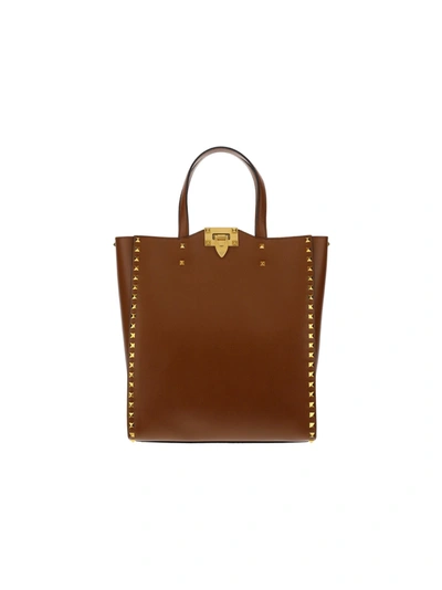 Shop Valentino Garavani Rockstud Top Handle Bag In Brown