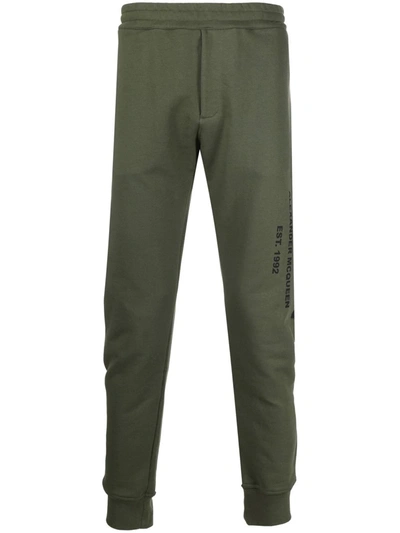Shop Alexander Mcqueen Logo Print Tapered Track Trousers In Grün