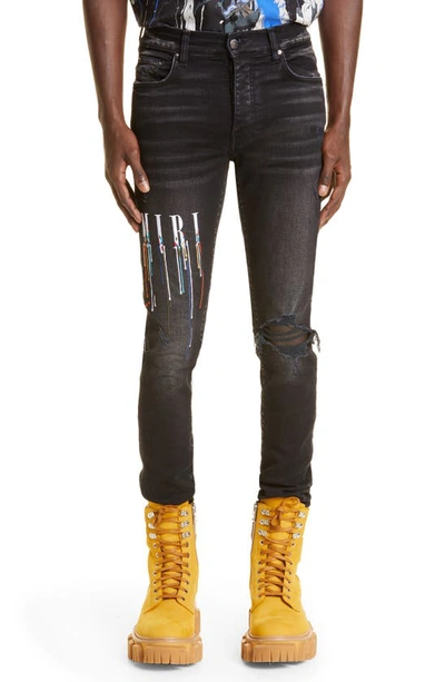 Shop Amiri Paint Drip Logo Ripped Skinny Jeans In Aged Black
