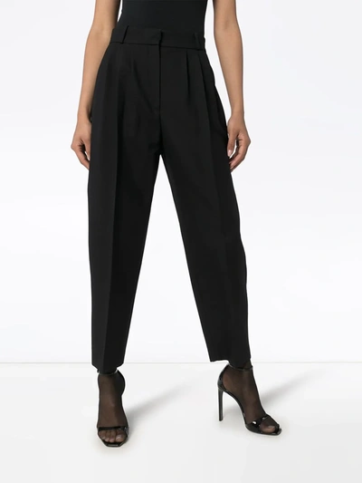 Shop Alexander Mcqueen Tapered Pleated Trousers In Black