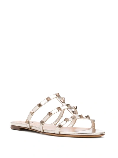 Shop Valentino Rockstud T-strap Sandals In Gold