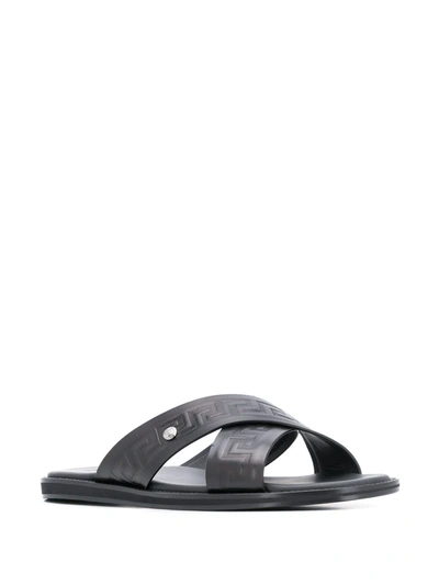 Shop Versace Embossed Greca Crossover Strap Sandals In Black